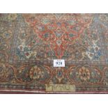 A signed Persian Kashan carpet with central motif on burnt amber field. In good condition. 225 x