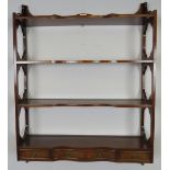 A set of reproduction mahogany serpentine fronted wall-hanging shelves in the Georgian taste, with