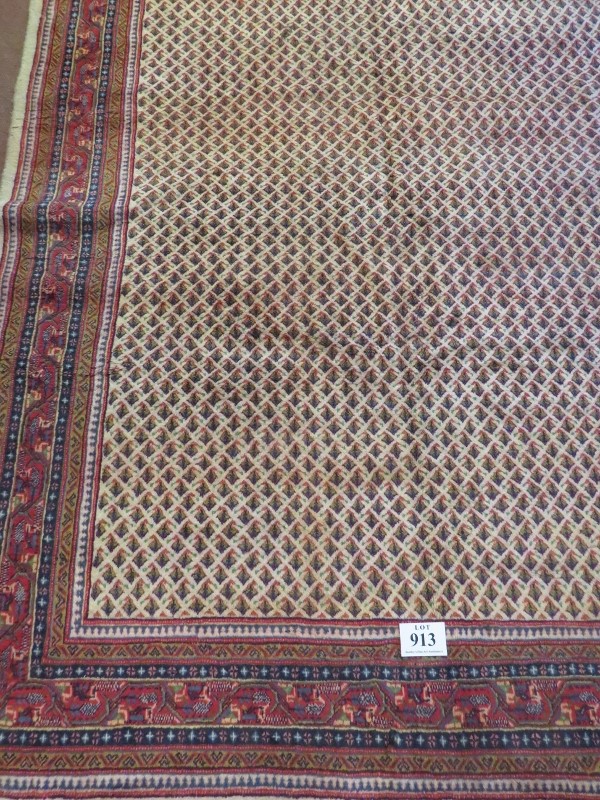 A North East Persian Sarouk Mir carpet central repeat pattern field on cream ground and deep border.