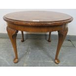 A 1920s figured walnut low circular coffee table, on acanthus carved cabriole supports with pad