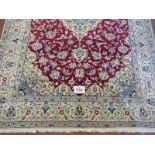 A Persian meshed rug, central cream floral motif on a red ground and cream borders. 255 x 165.