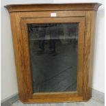 A turn of the century medium oak wall-hanging glazed corner cupboard, with two loose shelves.