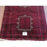 A Persian meshed rug, 3 central motifs on a burgundy ground. 216 x 120.