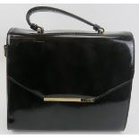 A Ted Baker black patent with gold coloured trim, with dust bag. Provenance: Part of a private