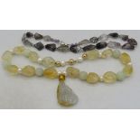 A Chinese necklace made up of irregular shaped citrine stones & baroque pearls with a jade pendant