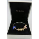 A Pandora white metal bangle with five 14ct gold beads, (2 with glass charms), marked G585 ALE.