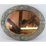 A Scottish Arts & Crafts oval bevelled mirror, early 20th century. Plated metal frame embossed