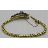 A fine Victorian yellow metal bracelet of serpent biting it's tail. The head is embellished with