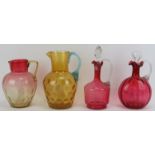 Four Victorian glassware items, late 19th century. Comprising two cranberry glass decanters with