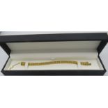 A heavy yellow gold plated jointed bracelet with X design and safety chain, boxed. Approx weight