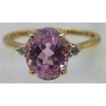 An 18ct yellow gold ring set with centre oval cut kunzite & small diamond either side. Kunzite