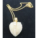 A heart shaped vintage seed pearl pendant with row of larger graduated pearls down the centre. The