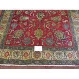 A North West Persian Tabriz rug, a central area depicting flowers on red ground, surrounded by a