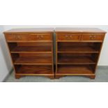 A pair of reproduction Yew wood open bookcases, crossbanded and strung with ebony, each housing