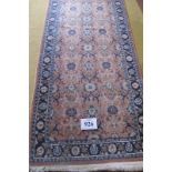 A late 20th century Persian runner, central repeat pattern on dusky pink ground and blue borders.