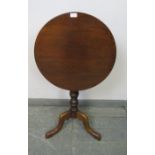 A 19th century mahogany circular tilt-top wine table, on a turned column with splayed tripod