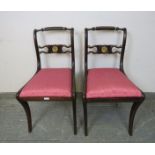 A pair of Regency Period mahogany rope back side chairs, the carved backrests with gilt brass