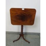 A late Georgian mahogany rectangular tilt-top wine table, on a turned column with splayed tripod