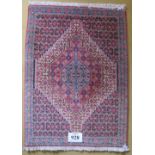 A small Persian rug, graduated central motif on blue ground with repeat pattern. 75cm x 110cm.