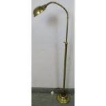 A vintage brass height adjustable floor-standing reading light with goose neck, on a circular plinth
