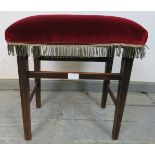 A King George V mahogany Coronation stool, upholstered in claret velvet on tapering square