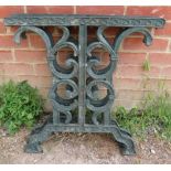 A pair of cast iron table supports painted green, with scrolled and pierced decoration. H66cm