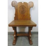 A medium oak hall chair in the Gothic taste, with relief carving to the reverse depicting an