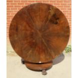 An early Victorian mahogany circular tilt-top dining table, the top with sectioned veneer, on a