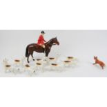 A Beswick ceramic fox hunting set. Comprising a huntsman, ten hunting dogs, and a fox. (12 items)