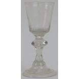 A Georgian period English drinking glass, mid 18th century. With a tear drop inverted baluster