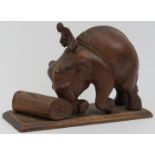 An Indian wood carving of a mahout riding an elephant moving a tree trunk, 20th century. 17.2 cm