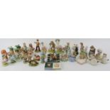 A large collection of Beatrix Potter ceramic figurines and a pin badge. Comprising twelve Beswick