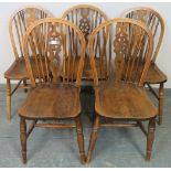 Five elm wheelback dining chairs, on turned supports with an ‘H’ stretcher. H89cm W41cm D47cm (