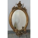 A 19th century oval girandole wall mirror in an ornate gilt gesso surround featuring moulded cornice