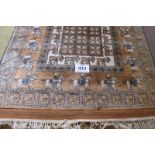An Afghan rug depicting figures on horseback, moose and wild cats, all on a tan field. 200 x 119cm
