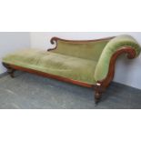 A Victorian mahogany show-wood chaise longue, upholstered in green velvet material, on tapering