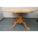 A stripped pine circular extending kitchen table, with additional central leaf, on a baluster turned