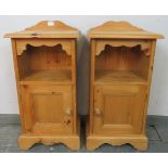 A pair of pine bedside cabinets with shaped galleries, above an open shelf with cupboard under, on