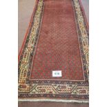 North East Persian Mir runner central small repeat pattern on red ground, with a wide border and