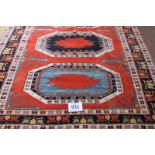 A 20th century Turkish rug with 3 geometric motifs on burnt amber field and in clean condition.