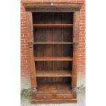 A very large open bookcase of reclaimed antique tropical hardwood, featuring carved frieze and