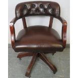 An antique style oak captain’s swivel desk chair with height adjust, upholstered in soft brown