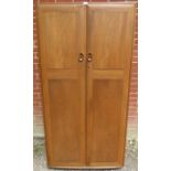 A mid-century blonde elm Windsor double wardrobe by Ercol, the doors opening onto a hanging rail,