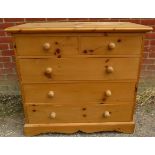 A pine chest of two short over three long drawers with turned wooden handles, on a plinth base