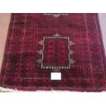 A Persian meshed rug, 3 central motifs on a burgundy ground. 216cm x 120cm.