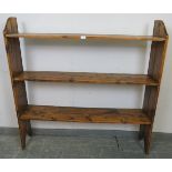 An antique pine open bookcase of three shelves, on stile supports. H122cm W122cm D25cm (approx).