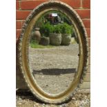 A 19th century oval bevelled wall mirror, in a moulded gilt gesso surround. H82cm W54cm D4cm (