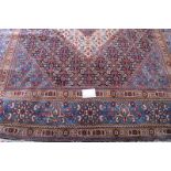 A fine Persian Tabriz carpet, central hexagonal motif on blue ground and in good condition. 390cm