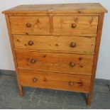 An antique pine shaker style chest of two short over three long graduated drawers with turned wooden