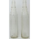 Two vintage Essolube clear glass motor oil bottles, early 20th century. Of cylindrical Art Deco